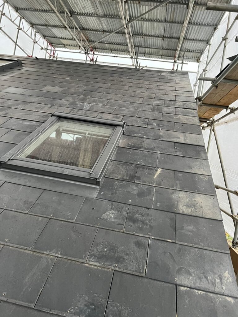 New slate roof installation in Surrey with roof window fitted by professional roofers